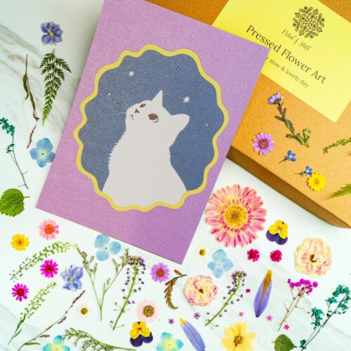 - Whimsical cat illustration on lavender background with stars, perfect for greeting cards and stationery, embodying playful and dreamy art style.