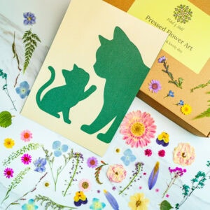 Silhouette of a cat and kitten cutout for pressed flower art, surrounded by colorful real pressed flowers and botanical paper, perfect for nature-inspired craft projects.