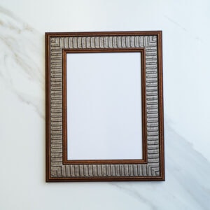 Ornate vintage picture frame with intricate geometric design on a white marble surface. Perfect for home decor, art displays, or DIY craft projects. Elegant and timeless accent piece.