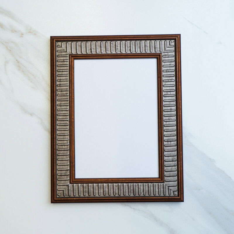 Ornate vintage picture frame with intricate geometric design on a white marble surface. Perfect for home decor, art displays, or DIY craft projects. Elegant and timeless accent piece.