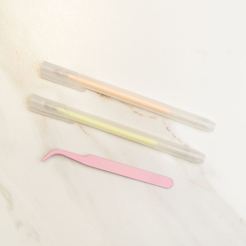 Syringe and microblading tools for eyebrow tattooing or semi-permanent makeup application on a white surface.